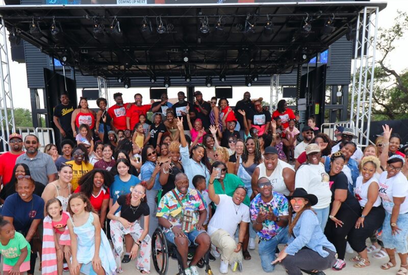 Community participants gathered after an outdoor event supported by ST315 mobile stage in San Antonio public plaza.